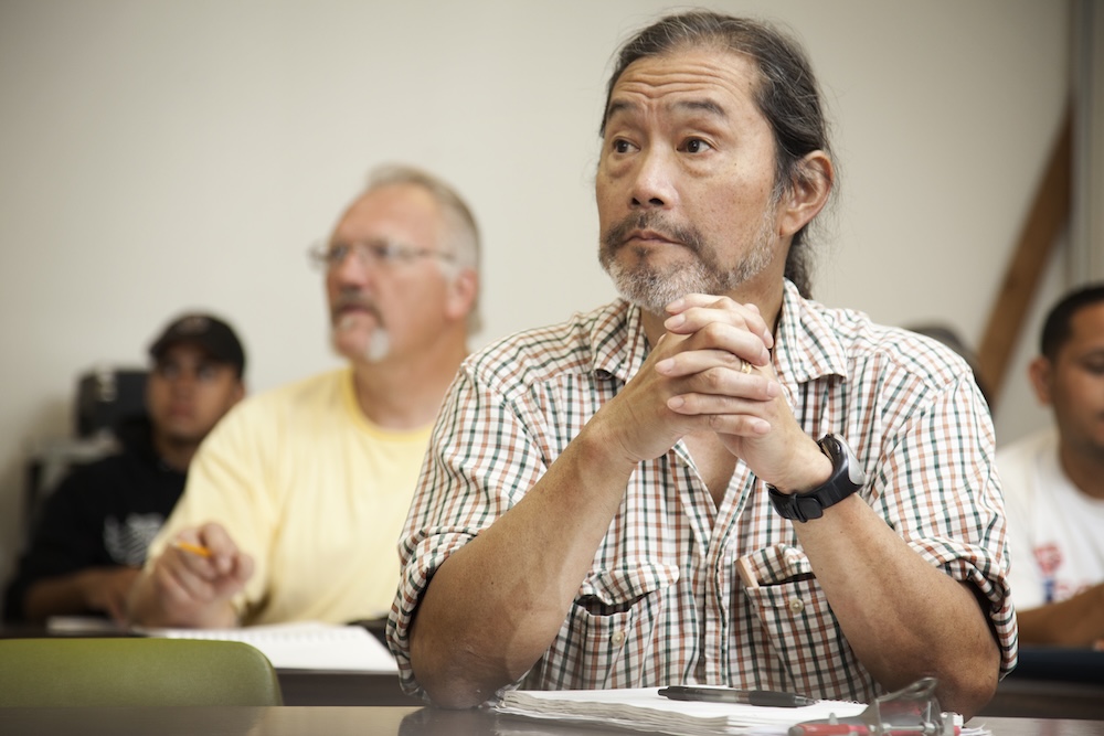 Senior man sitting at a desk in class