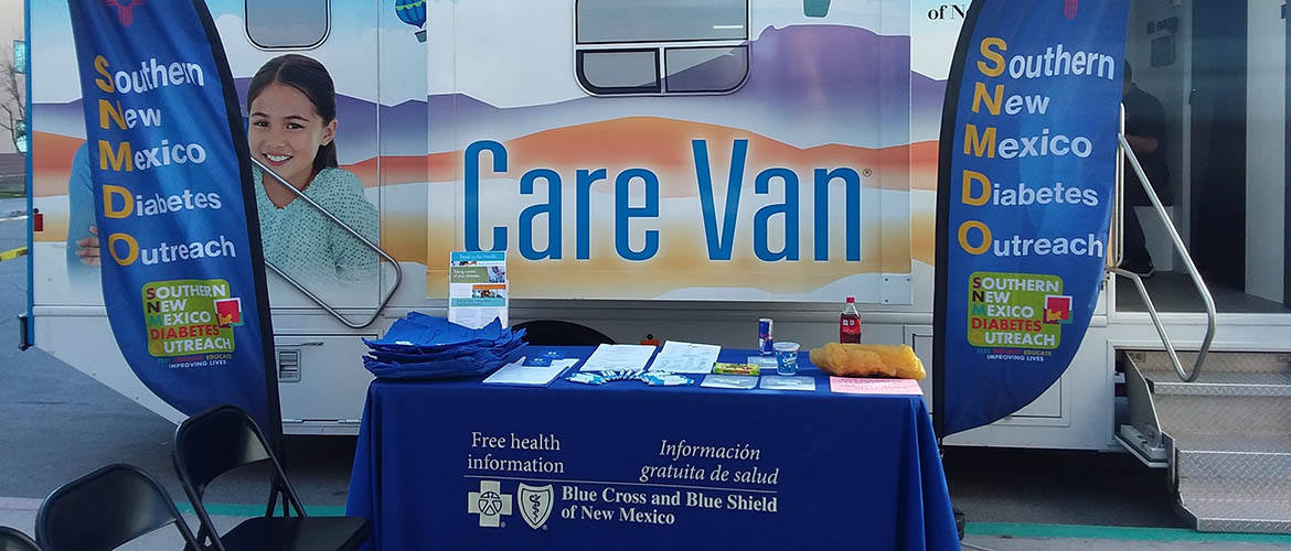 Diabetes information is offered on a table in front of a Care Van. 