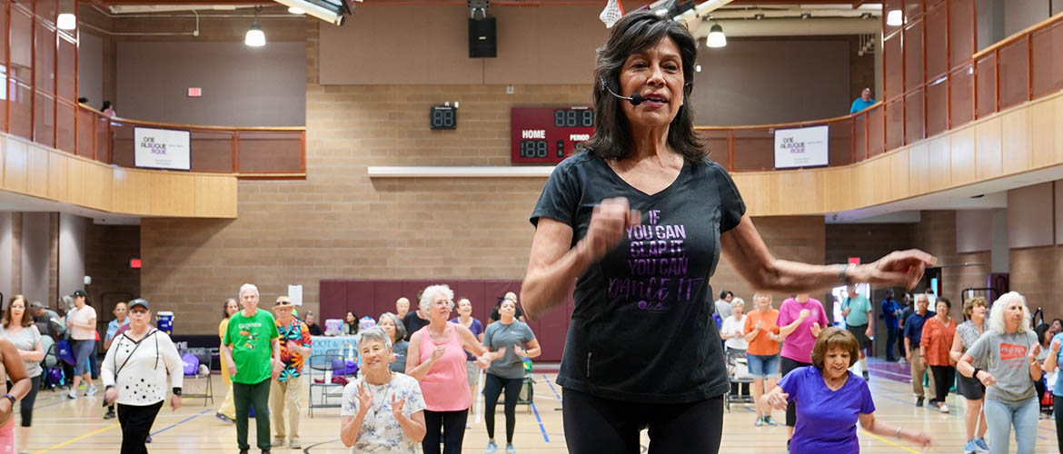 A fitness instructor leads older men and women in low-impact excercises 