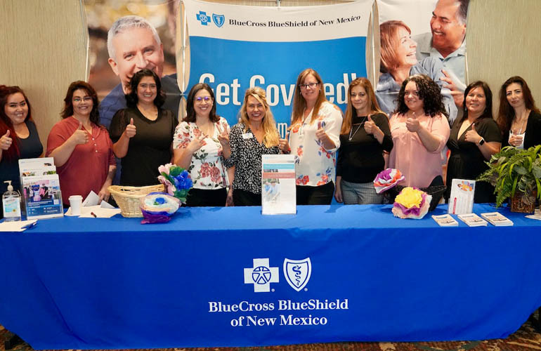Blue Cross and Blue Shield of New Mexico employees stand at an information table.