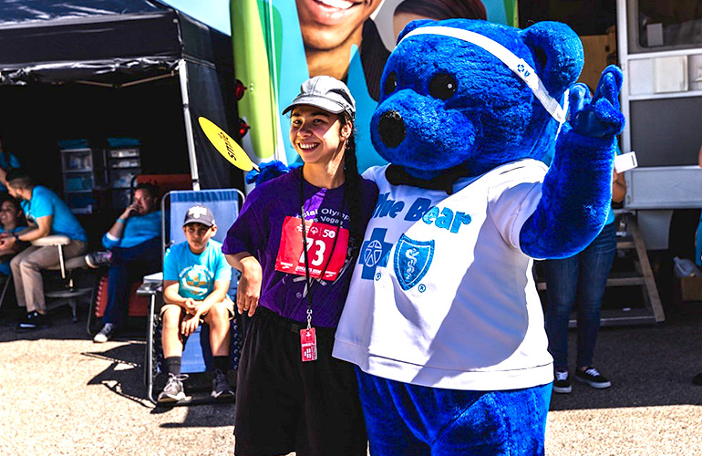 Special Olympics athlete poses with BCBSNM's Blue Bear