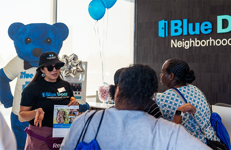 Health educator Julia Martinez shares with guests information about the Blue Door Neighborhood Center.