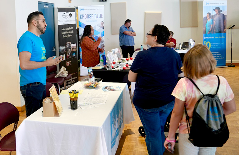 Visitors look at booths with information about preventive health services. 