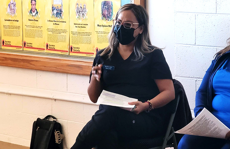 Woman wearing a mask speaks to a group