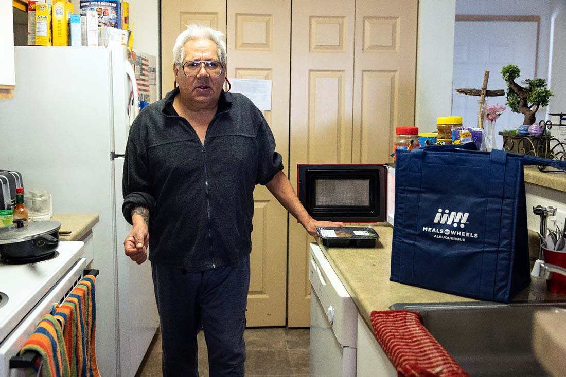 Robert Montanez in his kitchen with food delivered by Meals on Wheels of Albuquerque
