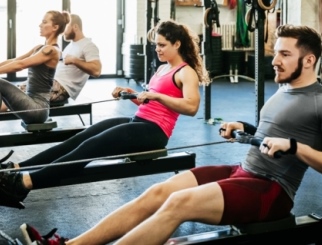 Man and woman rowing in a fitness center