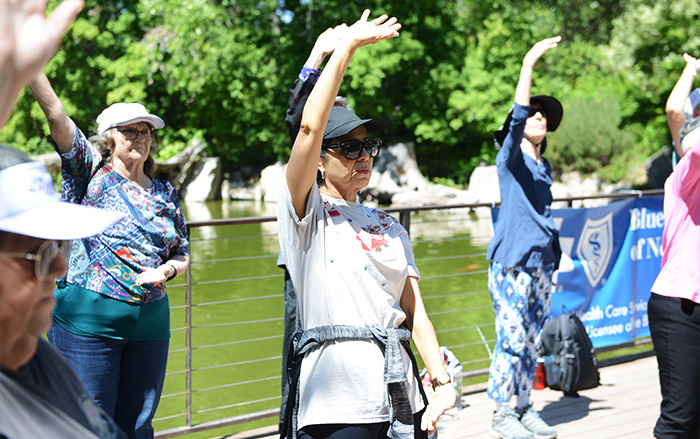 Adultos mayores participan en ejercicios de Tai Chi en el Jardín Japonés.