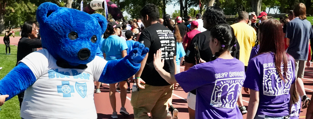 Blue Bear choca los cinco con un miembro de la comunidad en un evento al aire libre