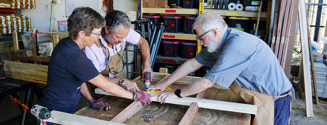 Tres personas trabajan juntas para construir una rampa de accesibilidad