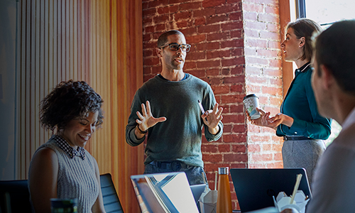 A diverse group of employees collaborates together in office space