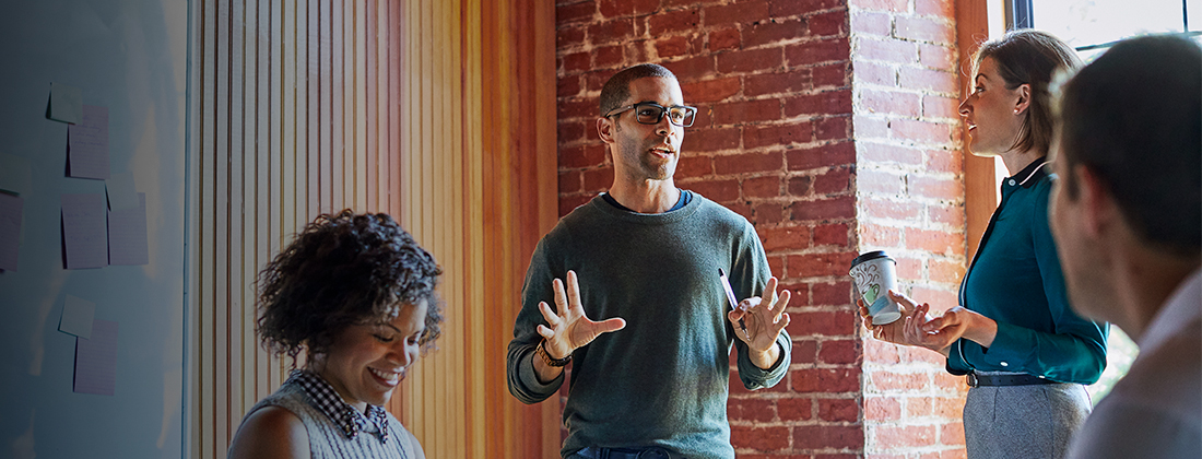 A diverse group of employees collaborates together in office space