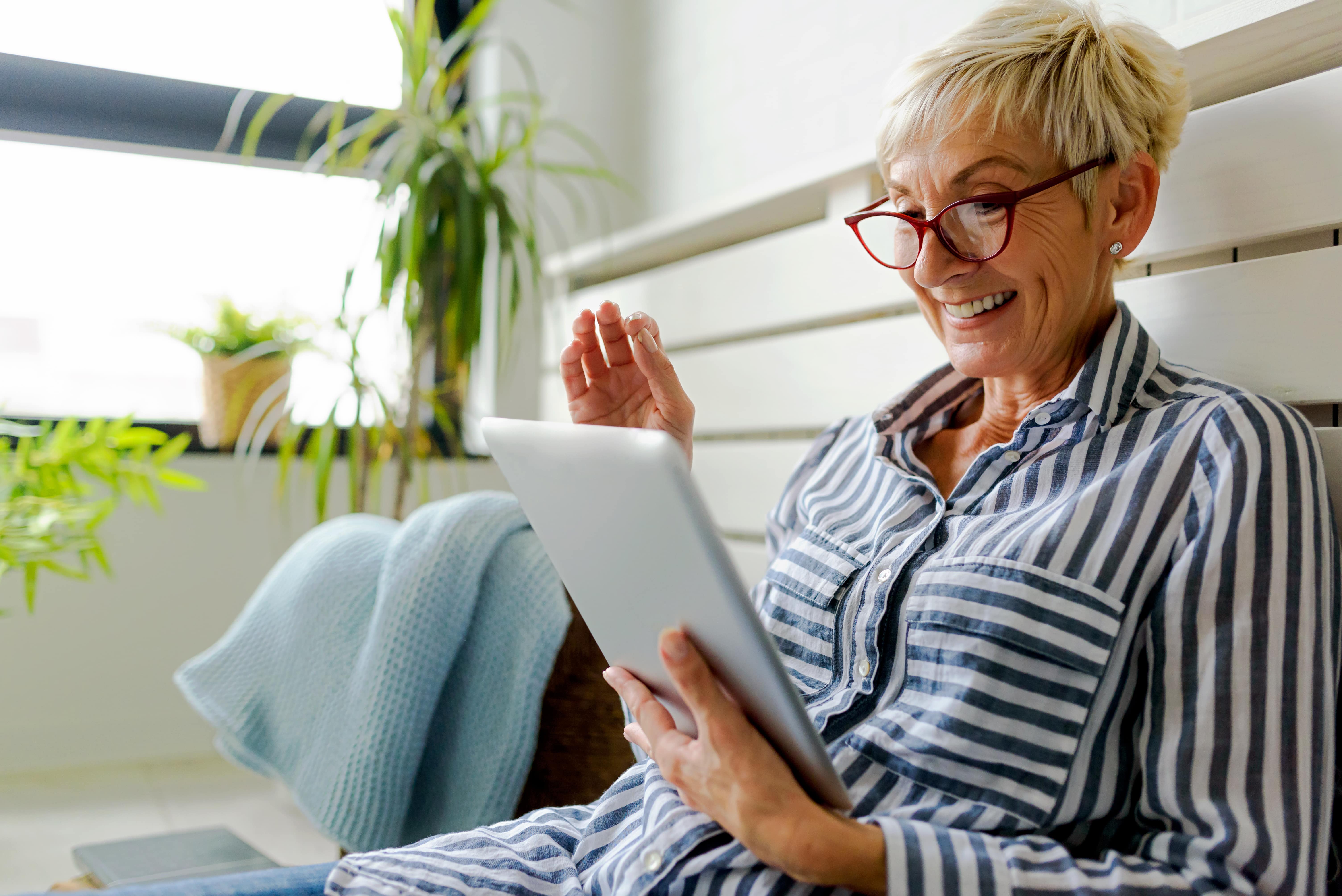 Mujer sonriendo y sosteniendo una tableta